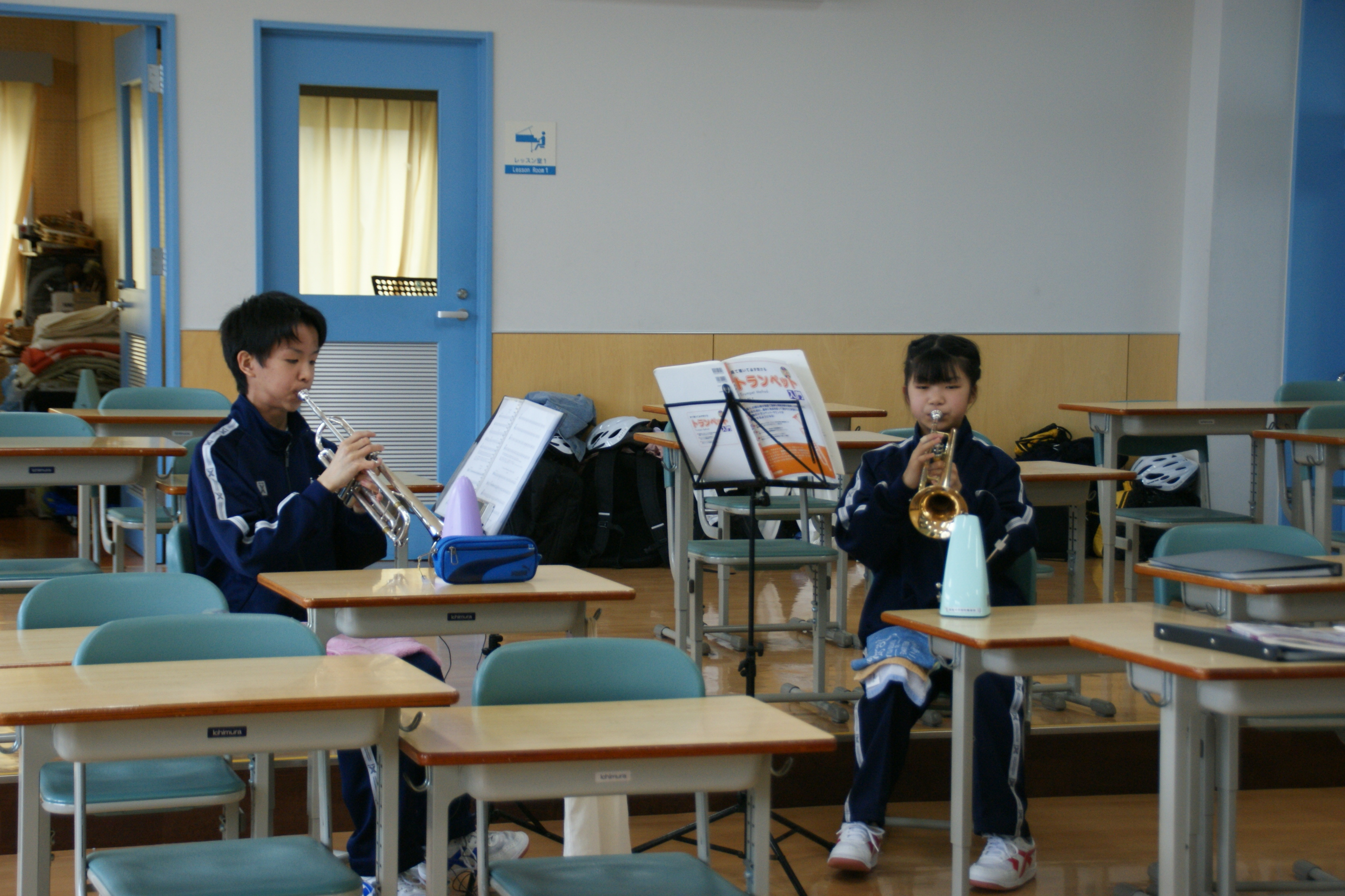 2年生の先輩と一緒に音出しをする1年生